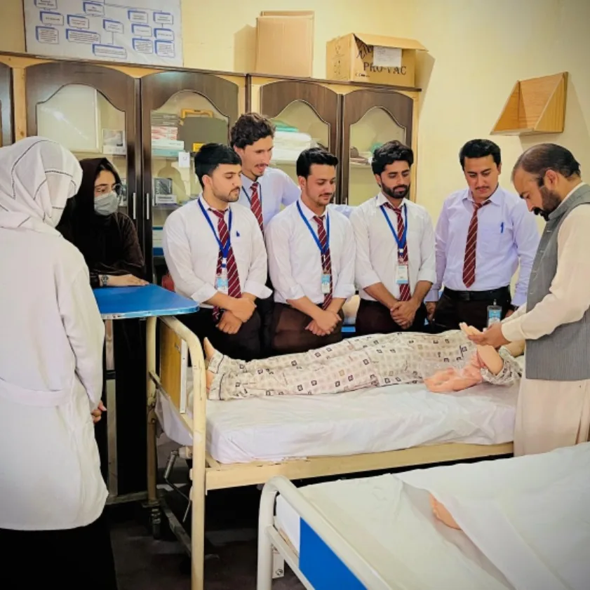 Students gathered around a hospital bed for a bedside demonstration